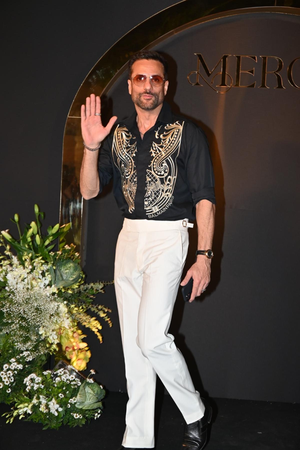 Fardeen Khan looked stylish in a black shirt with a golden design on it. He paired it with white pants.