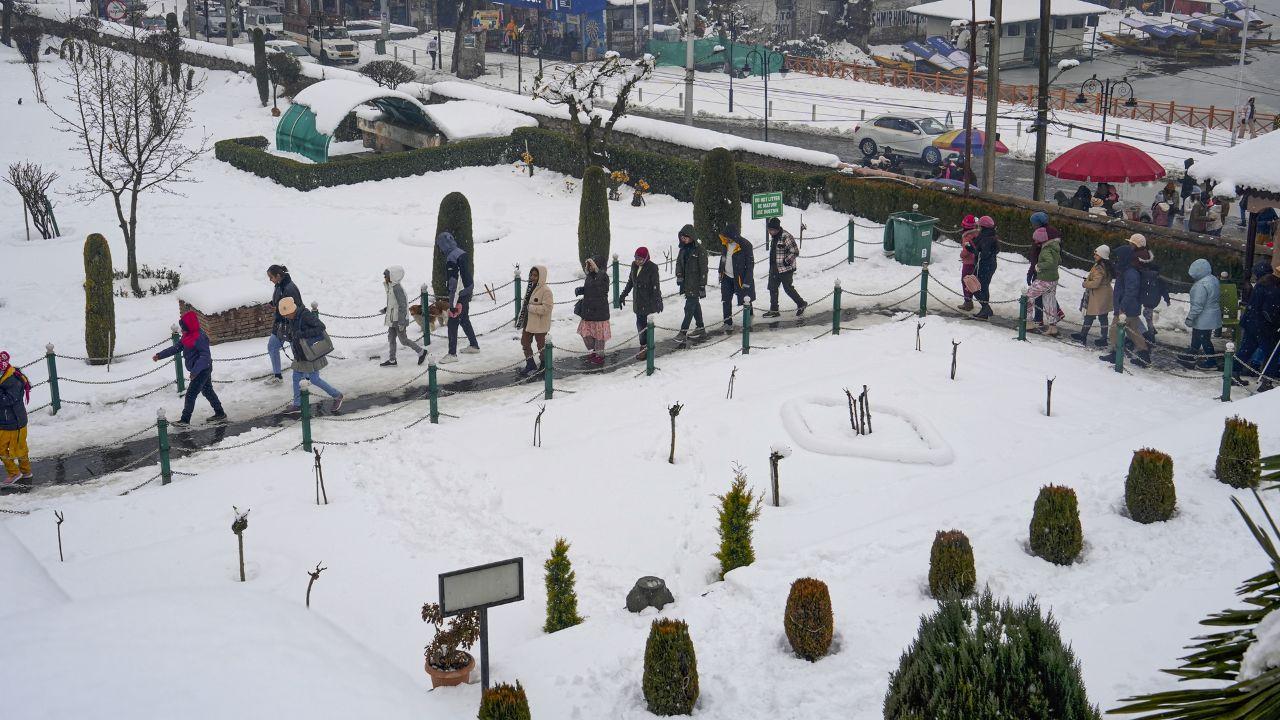 Visitors at the Nishat Garden near the Dal Lake after the season's first snowfall. (Pic/ PTI)