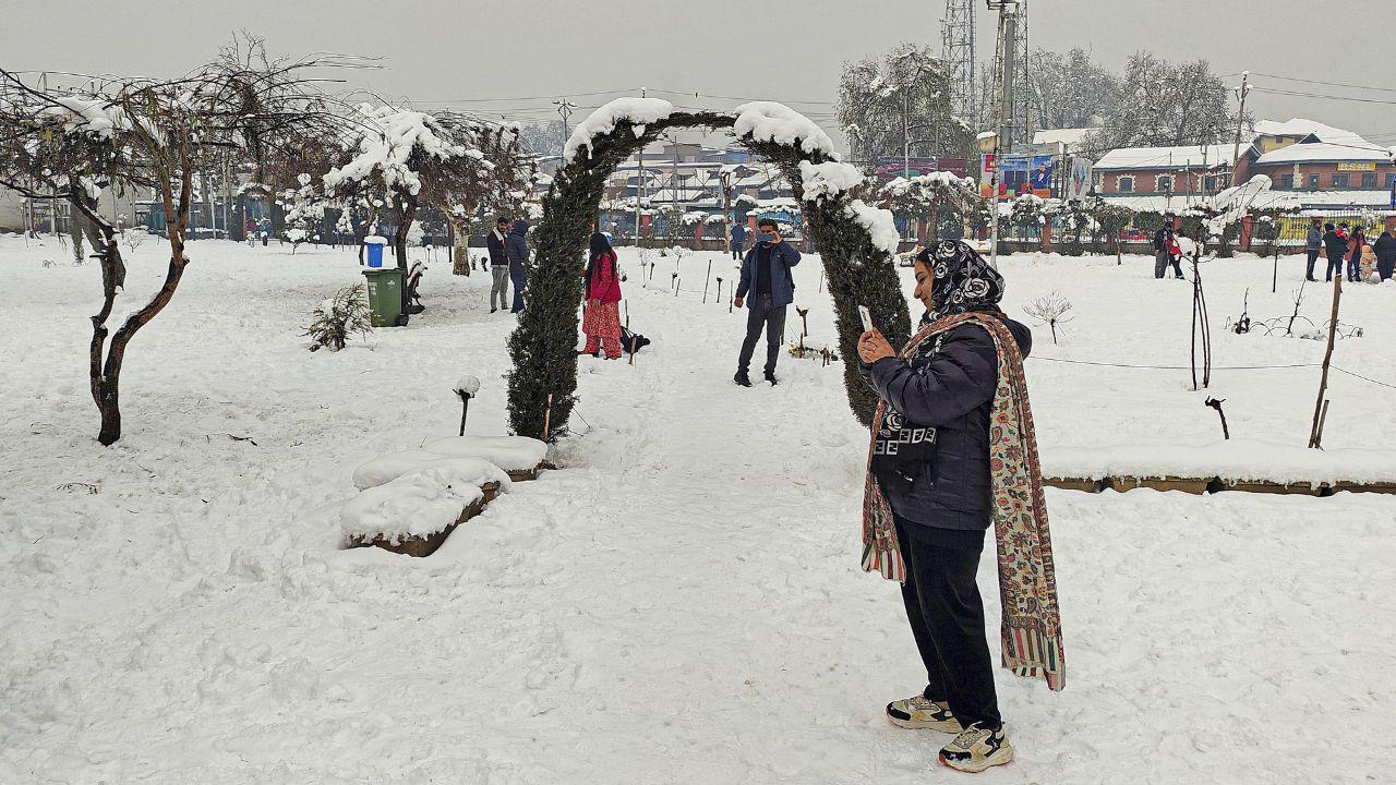 Visitors at a snow-covered park in Srinagar. (Pic/ PTI)