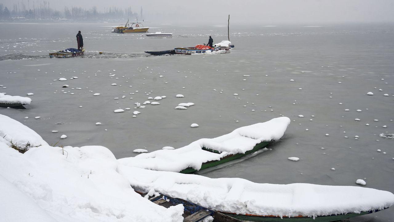 ‘Shikaras’ are seen parked at the Dal Lake after the season's first snowfall, in Srinagar. (Pic/ PTI)