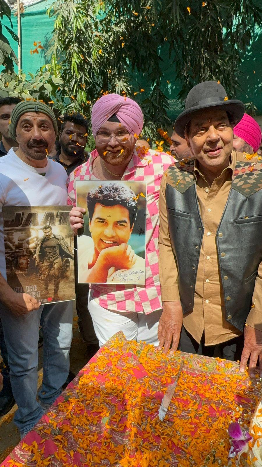 The trio stepped out to greet fans and media who had gathered to wish the icon on his special day. Dharmendra was welcomed with a floral shower. 