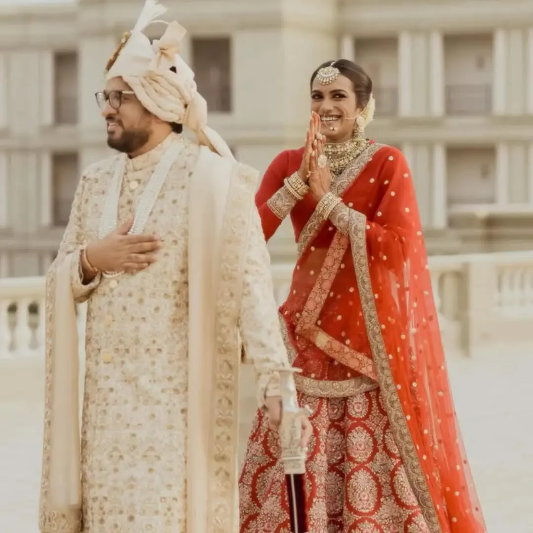 PV Sindhu and Venkata Datta Sai donned several stunning looks during their traditional wedding ceremony. In this look, while Datta stunned in an all-white sherwani, Sindhu looked gorgeous in a classic Sabyasachi red lehenga.