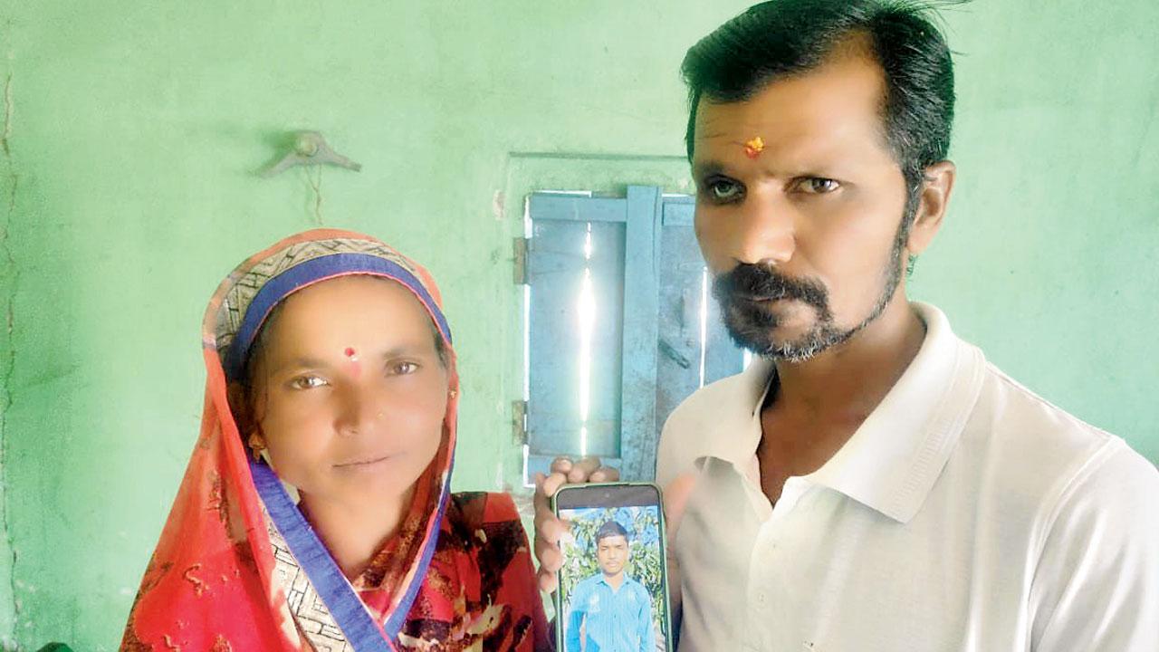 Avishkar Jagtap’s parents displaying his photograph