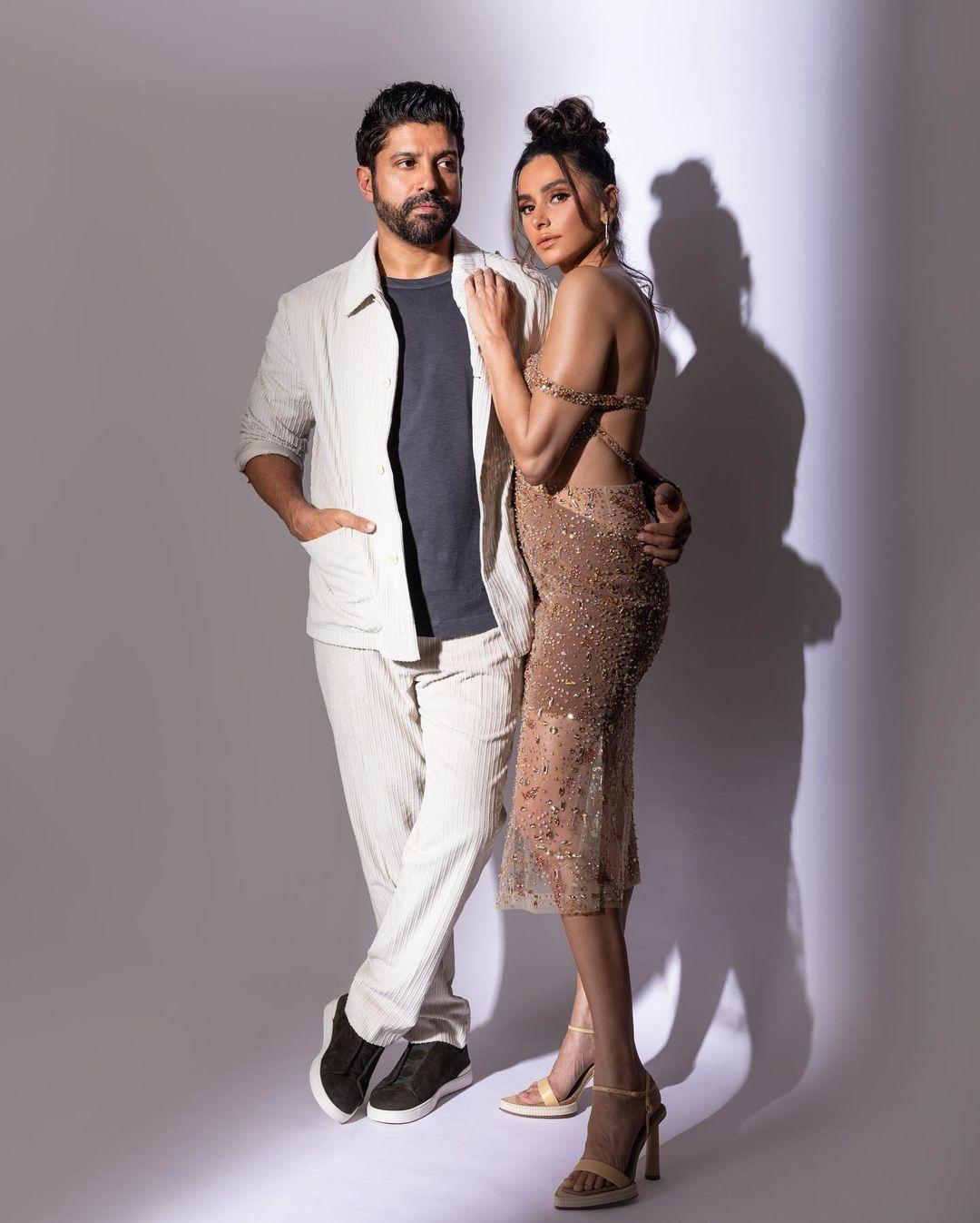 In this look, Shibani wore a glittery off-shoulder dress and put a chic bun with nude makeup, while Farhan complemented her with a grey T-shirt paired with white pants and a matching shirt