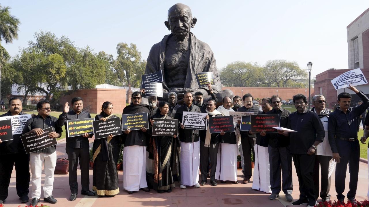 DMK MPs stage a protest at the Mahatma Gandhi statue against the BJP-led Centre over alleged neglect and partiality in allocation of funds to the states, at the Parliament House complex. Pics/PTI