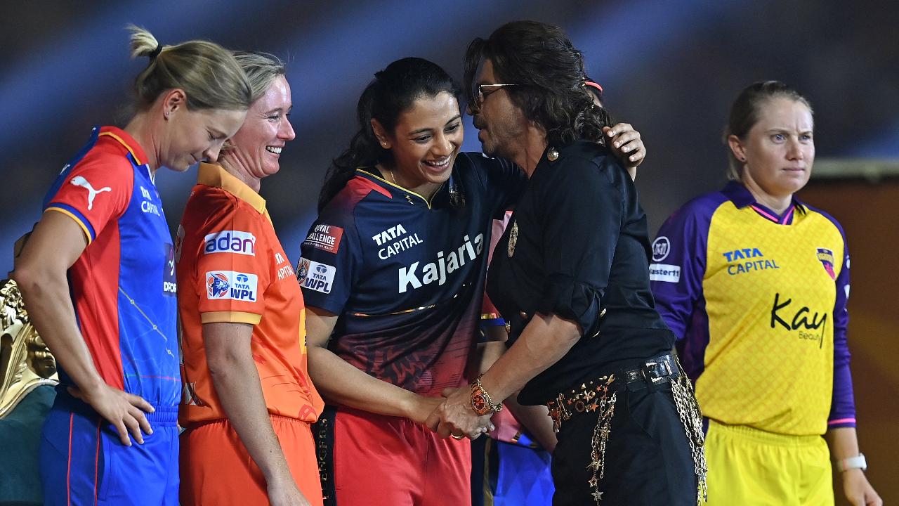 Bollywood actor Shah Rukh Khan (2R) greets Royal Challengers Bangalore's captain Smriti Mandhana (C) during the opening ceremony of 2024 Women's Premier League (WPL) before the start of first Twenty20 cricket match
