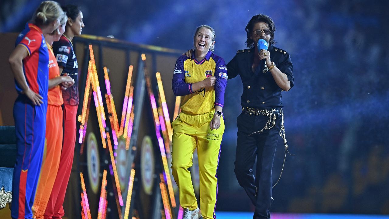 UP Warriorz's captain Alyssa Healy (2R) and Bollywood actor Shah Rukh Khan (R) gesture during the opening ceremony of 2024 Women's Premier League (WPL) before the start of first Twenty20 cricket match between Mumbai Indians and Delhi Capitals