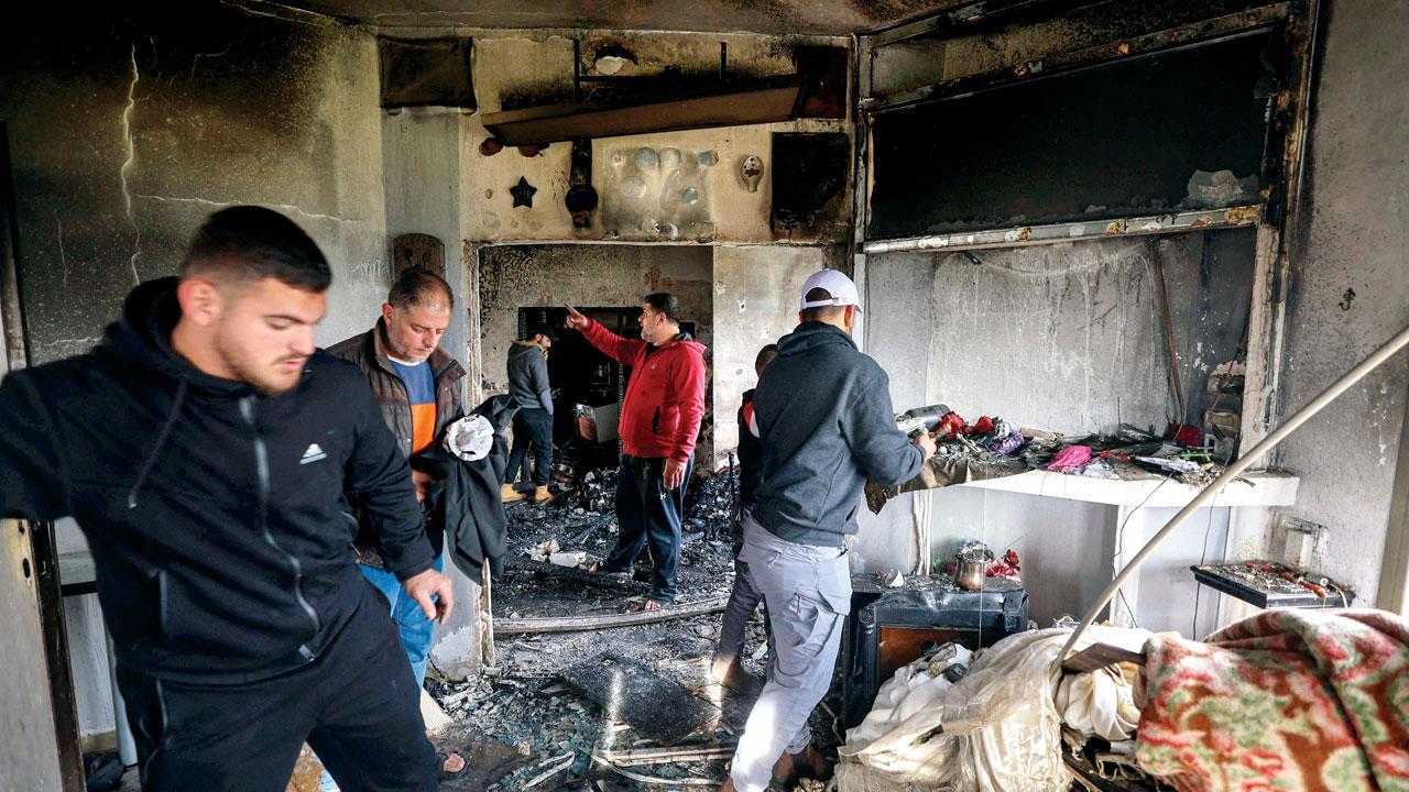 Palestinians inside a house damaged during a raid by Israeli forces looking for wanted militants in Jenin. Pic/AFP