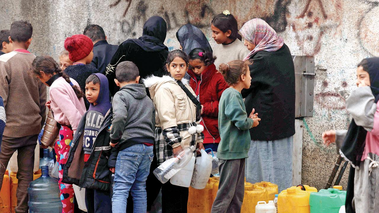 Women and children queue for water. Pics/AP