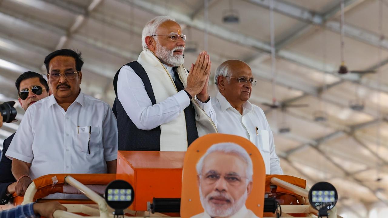 PM Modi waved at the excited gathering during the roadshow where he was accompanied by Gujarat Chief Minister Bhupendra Patel and Navsari MP CR Patil