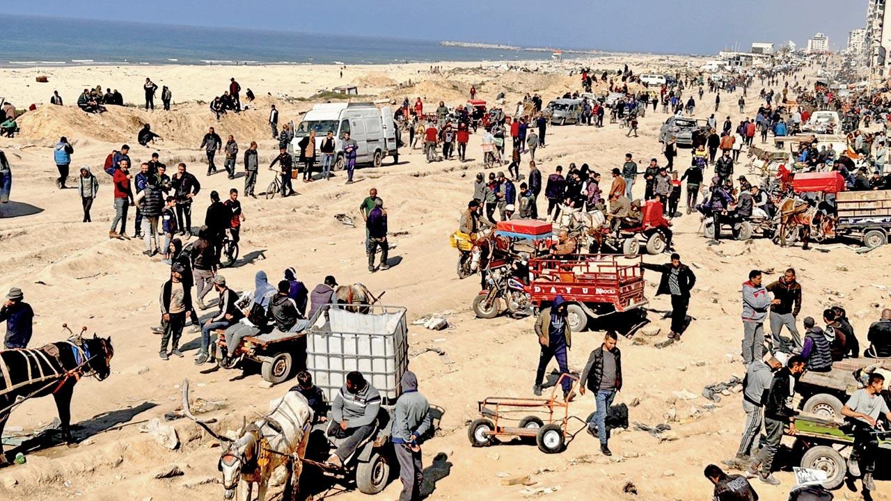 Palestinians wait for humanitarian aid on a beachfront in Gaza City. Pic/AP
