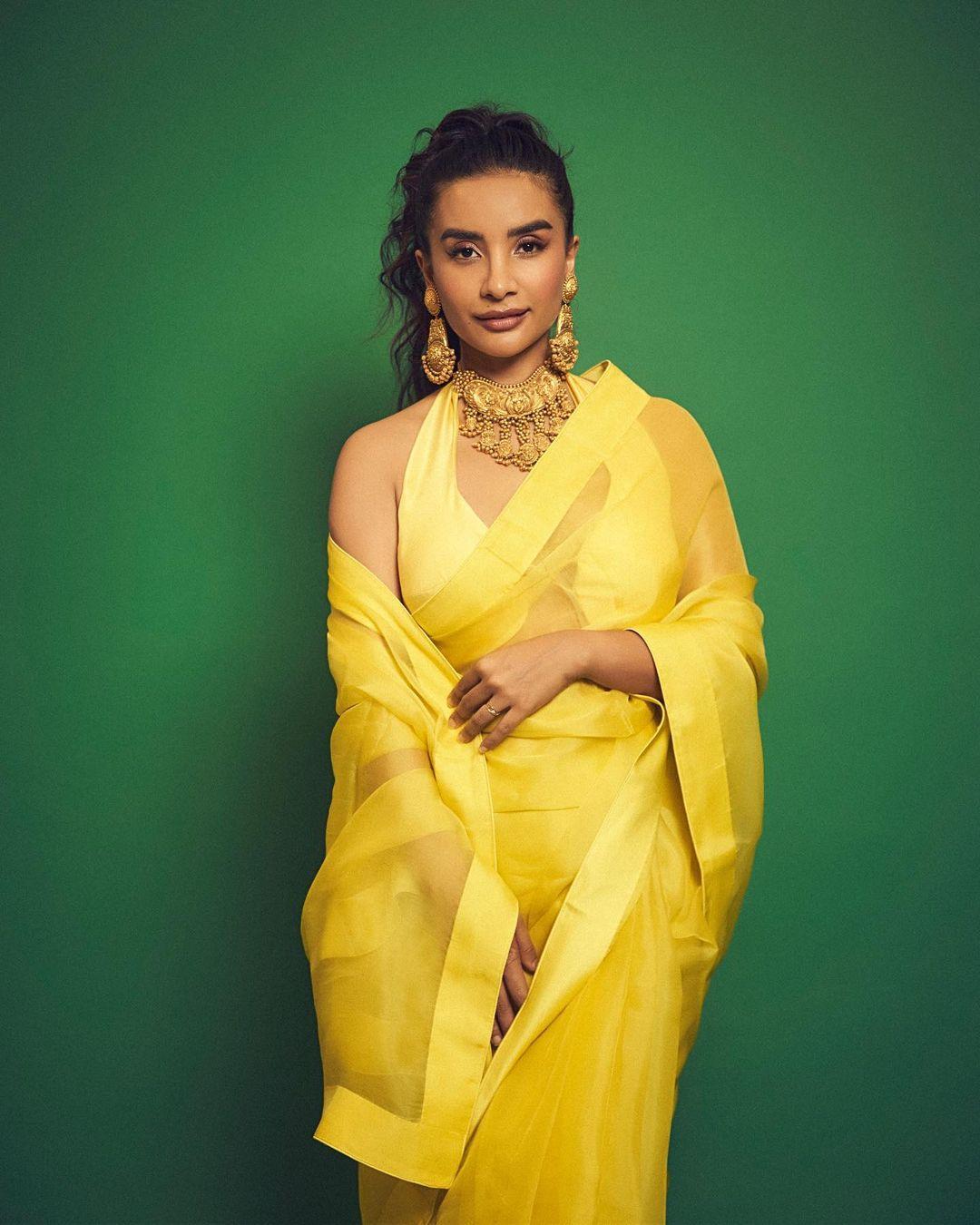  In this look, the actress opted for a stunning yellow see-through saree, which is just perfect for attending any haldi function. She paired the saree with heavy jewellery and tied her hair in a messy ponytail. To maintain the balance, Patralekhaa opted for nude makeup