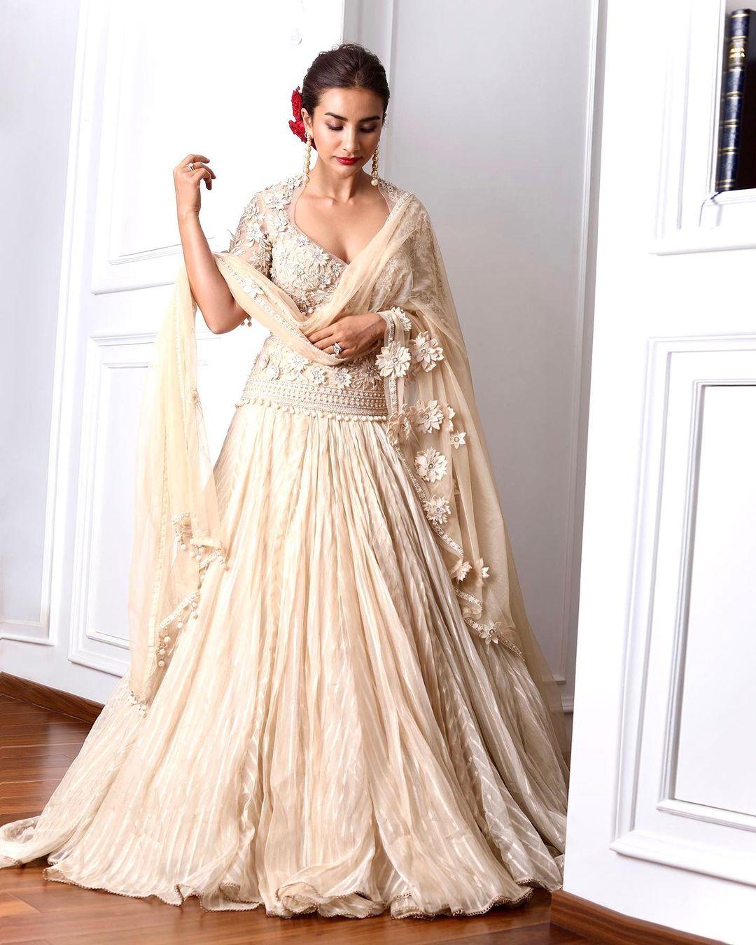  By forgoing heavy jewellery, Patralekhaa tied her hair in a chic bun while adding contrast with bold red lipstick and decorating her bun with roses