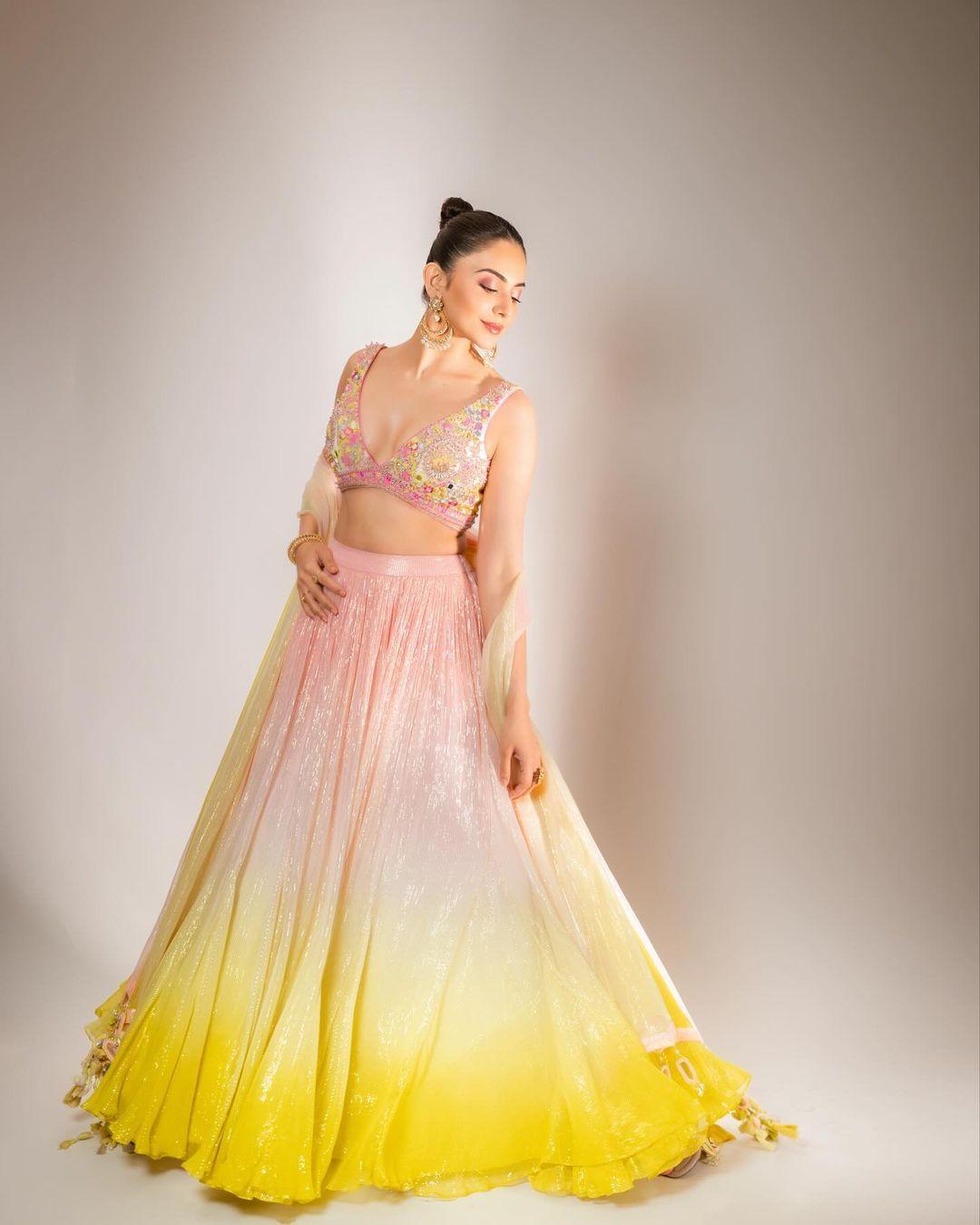 Rakul steals hearts once again in a pastel lehenga. The actress dons a shiny lehenga with a matching heavily embroidered blouse