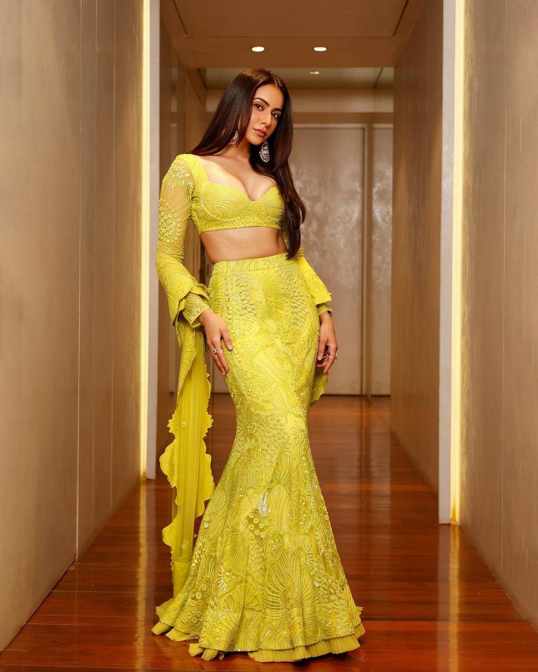 For another stunning appearance, Rakul chooses a beautiful lime green lehenga set. The heavily decorated fish-tail lehenga is paired with a matching blouse and dupatta