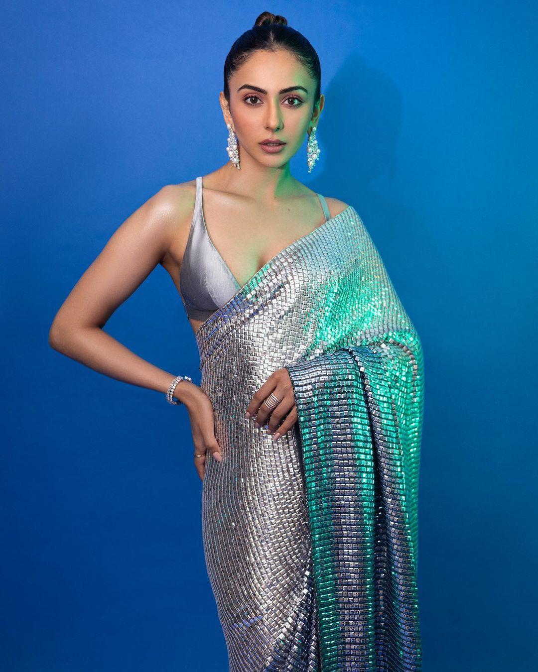 The actress accentuates her outfit with long white earrings and a few bangles, adding a touch of sophistication