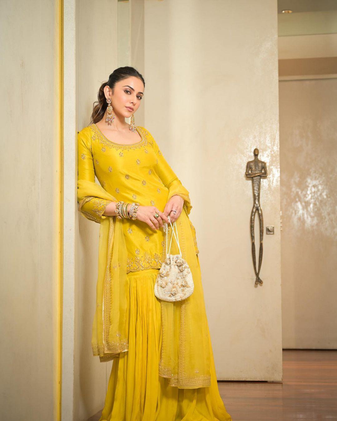 Rakul's impeccable fashion sense extends to suits as well. In this particular look, she rocks a yellow sharara suit with her hair styled in a messy ponytail