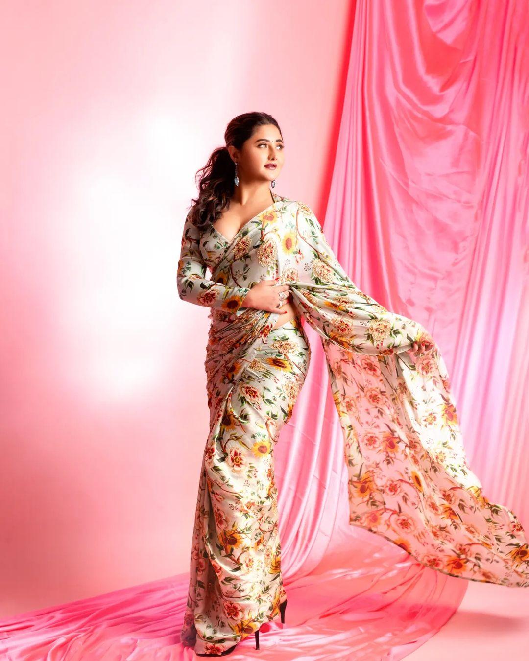  Rashami Desai mesmerizes in a printed floral saree, exuding charm. The matching deep neck blouse complements the pretty saree