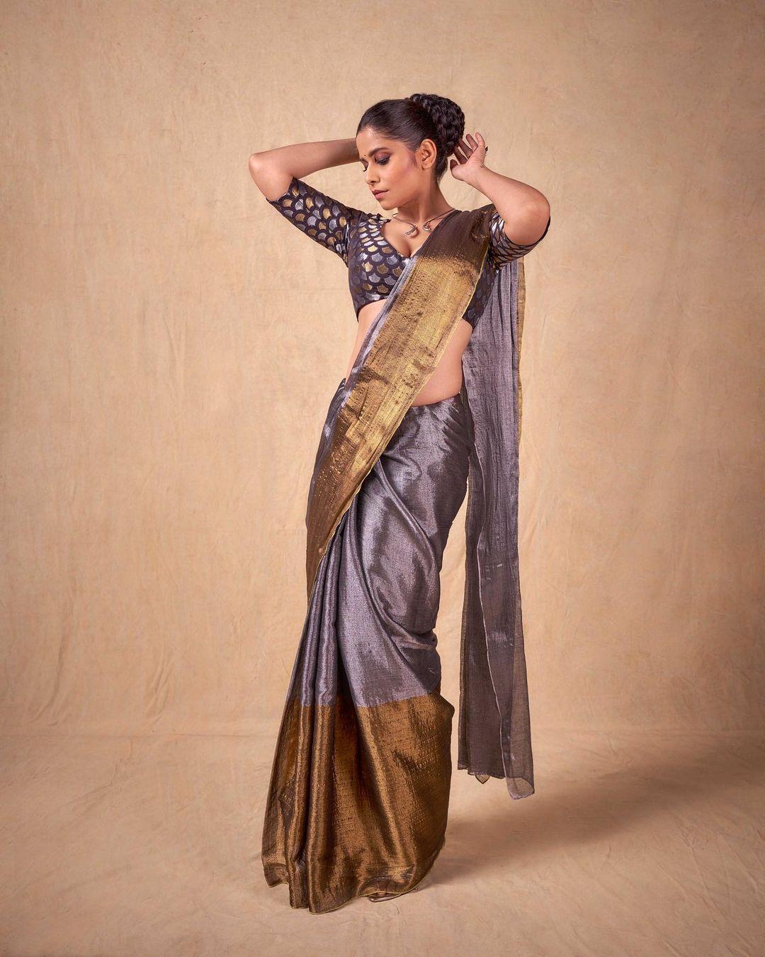 Sai Tamhankar consistently delights her fans with her impeccable fashion sense, particularly in traditional wear. In this captivating look, Sai donned a stunning grey saree with a broad golden border, radiating timeless charm