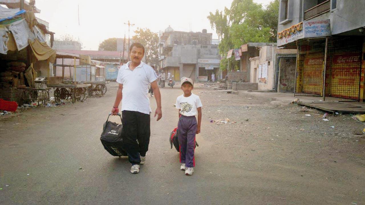 Sachin Dhas (right), aged six, heads to practice with dad  Sanjay in Beed