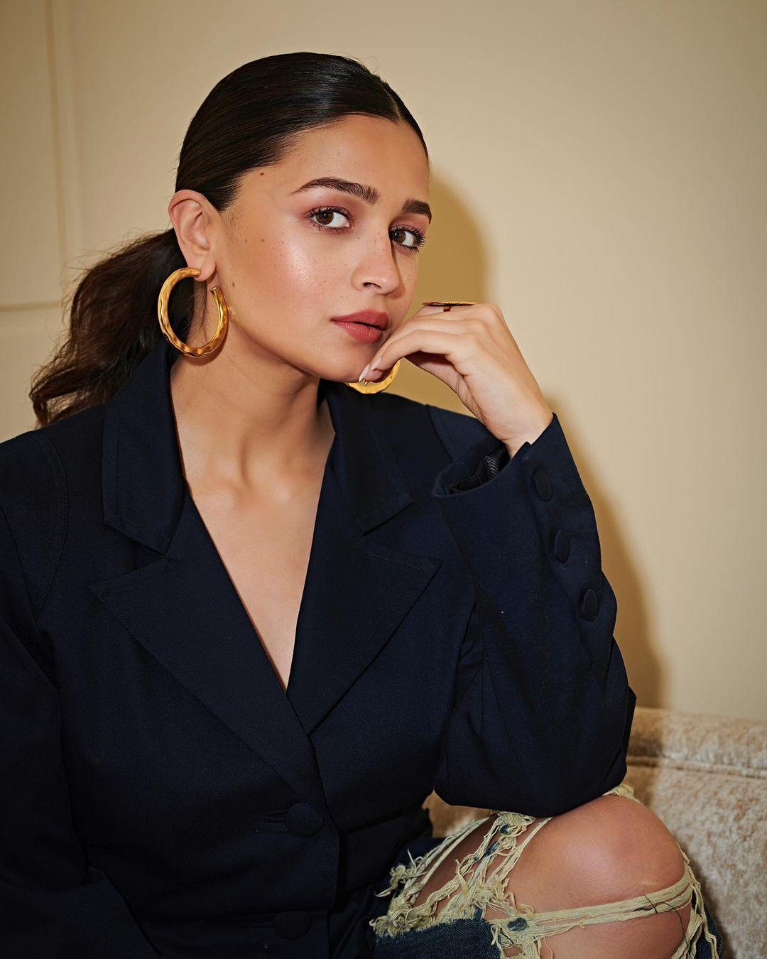 Her makeup included contoured cheeks, mascara-coated eyelashes, and a hint of glossy brown on her lips. To complete the polished look, she opted for a sleek middle-parted ponytail.
