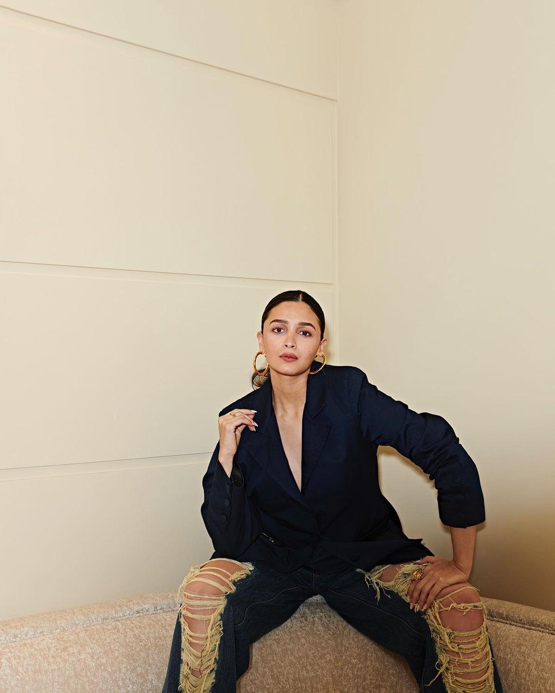 Alia Bhatt is the picture of corporate aesthetic – a stylish black blazer with power shoulders, flawlessly paired with dark blue ripped jeans for a blend of professionalism and chic.