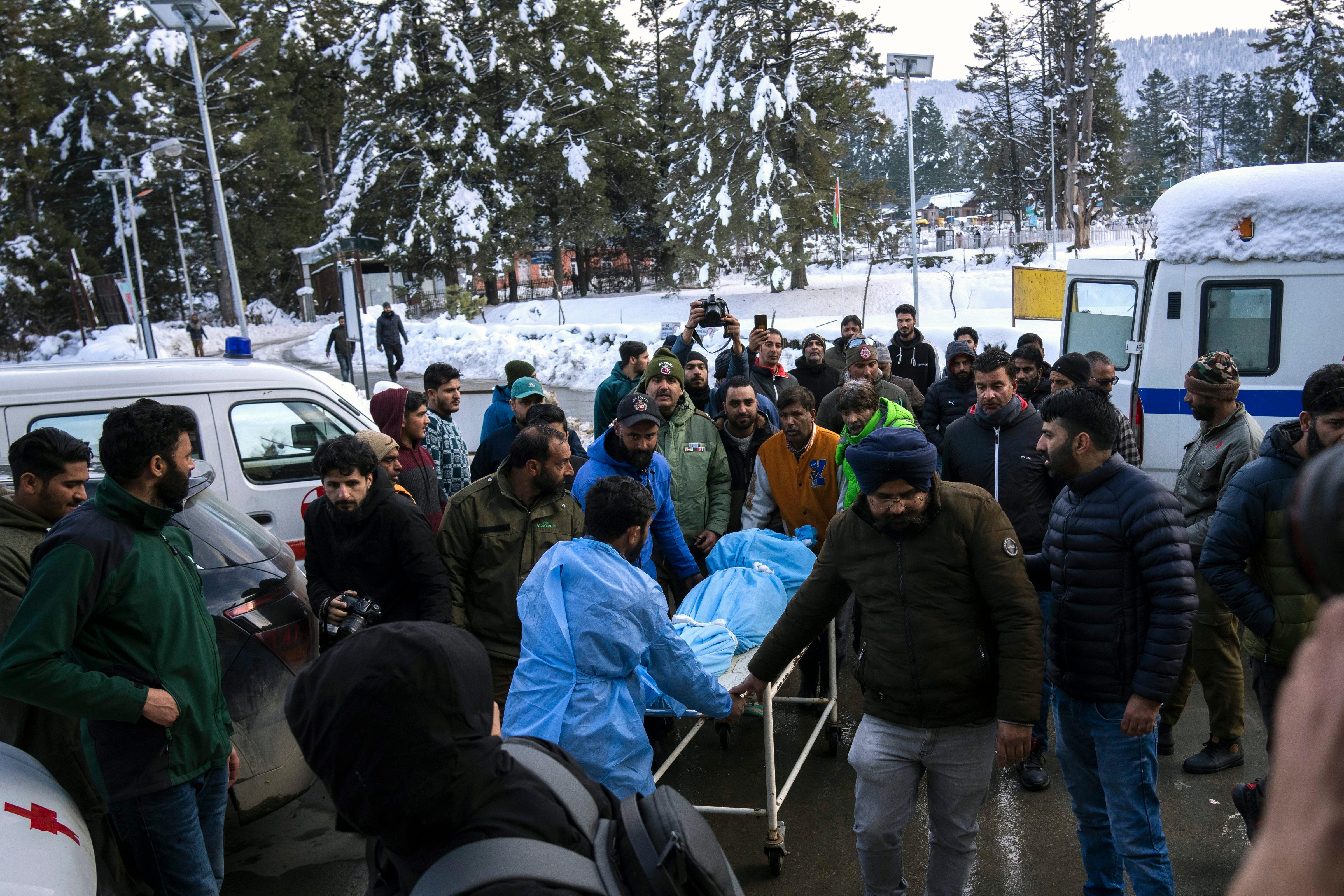 Paramedic and volunteers transported the body of a Russian skier to a hospital in Tangmarg, near Gulmarg