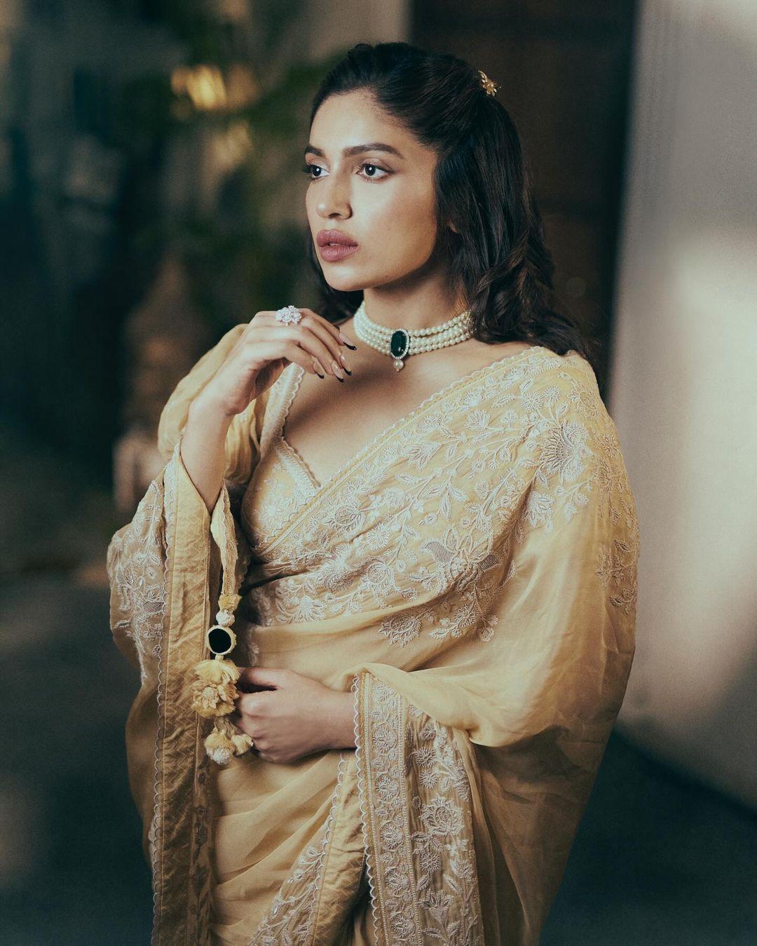 Bhumi applied sharp makeup, enhancing her appearance. She adorned a stunning pearl necklace with a contrasting green gem. Tying her hair in a stylish hairstyle, Bhumi added a potli bag to finish her appearance
