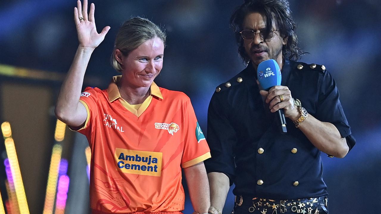 Gujarat Giants' captain Beth Mooney and Bollywood actor Shah Rukh Khan (R) gesture during the opening ceremony of 2024 Women's Premier League (WPL) before the start of first Twenty20 cricket match between Mumbai Indians and Delhi Capitals