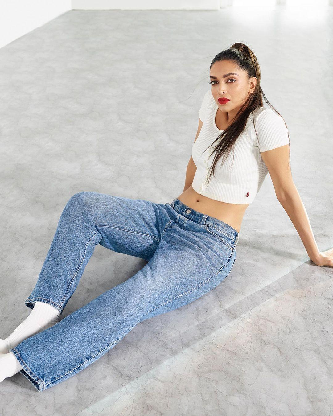 Deepika Padukone pulls off an amazing summer chic look, rocking a white crop top with light blue jeans and socks.