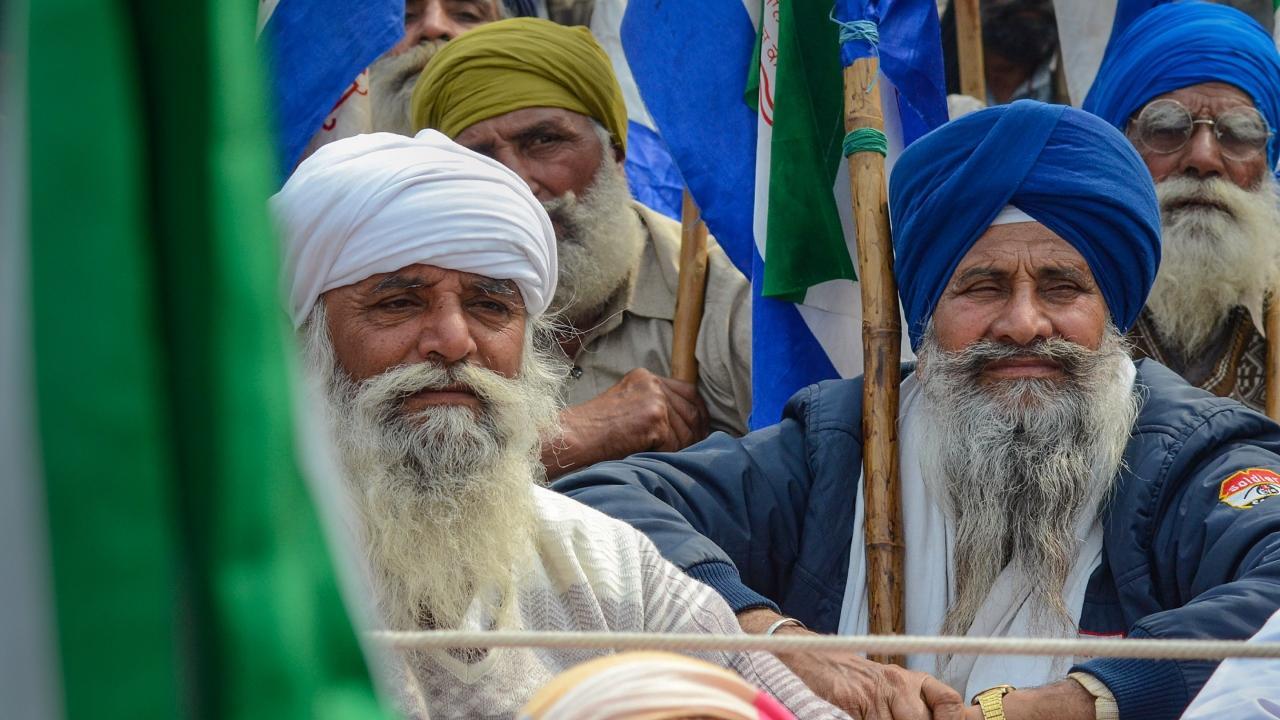Farmers listen to a leader at the Punjab-Haryana Shambhu border during their 'Delhi Chalo' protest, near Patiala district on sunday. Pics/PTI