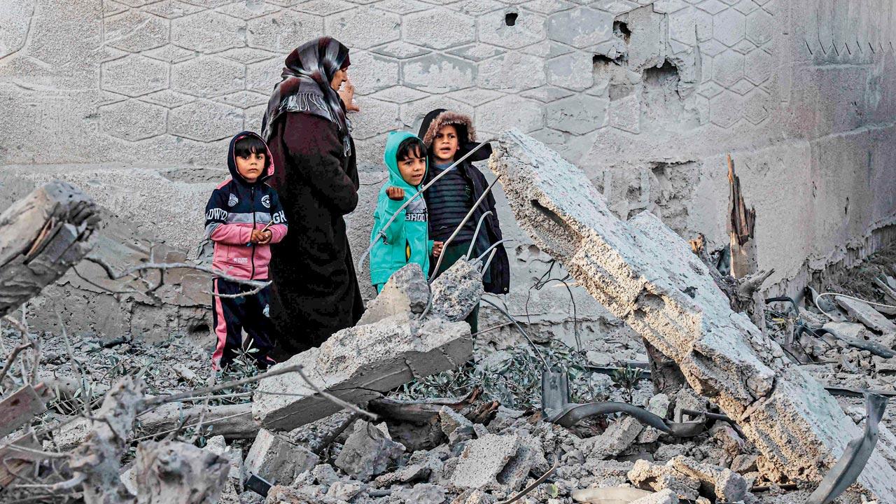 Palestinians amid the rubble of damaged buildings after Israeli bombardment in Rafah on Monday. Pic/AFP 