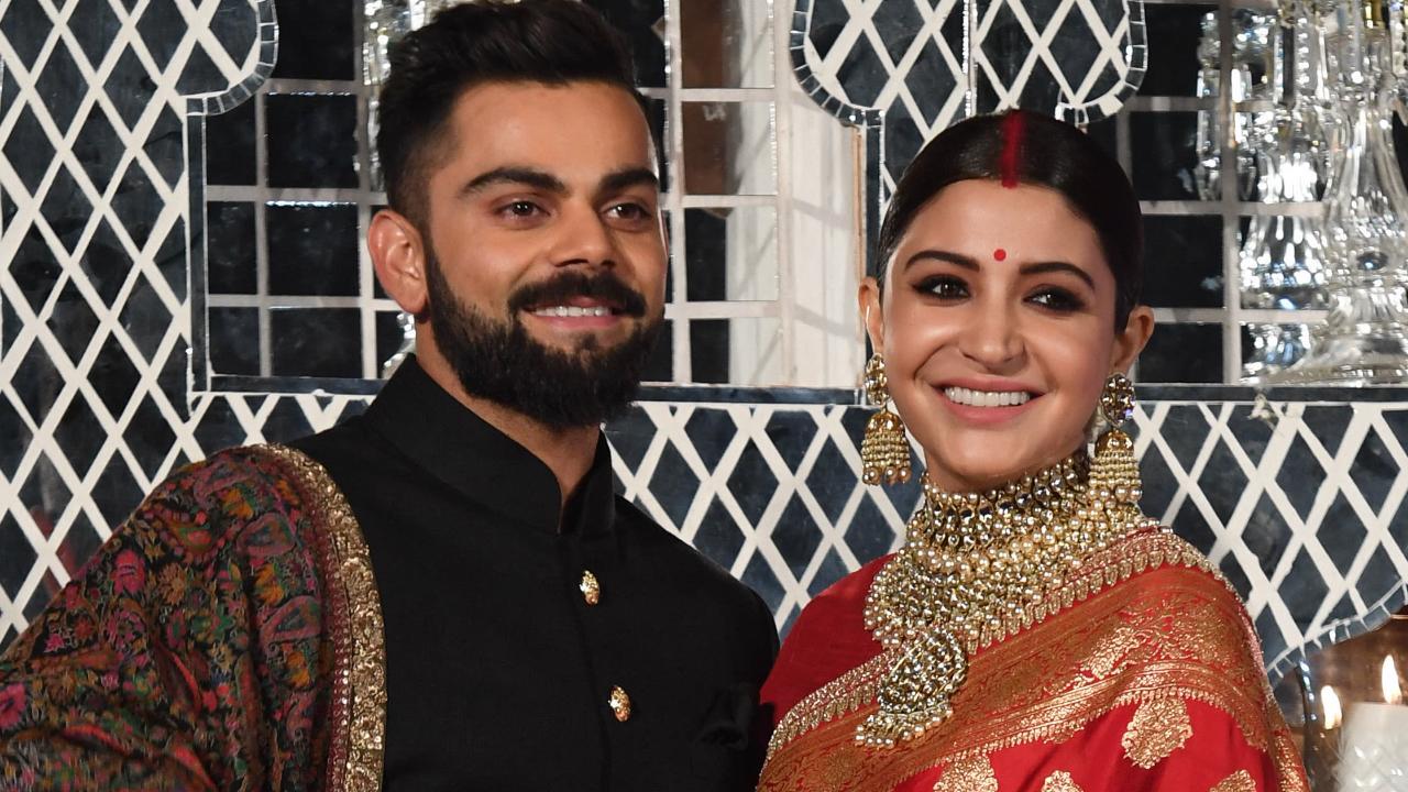 Virat Kohli (L) and Bollywood actress Anushka Sharma, who were married in Italy, pose during a reception in New Delhi on December 21, 2017 (Pic: AFP)