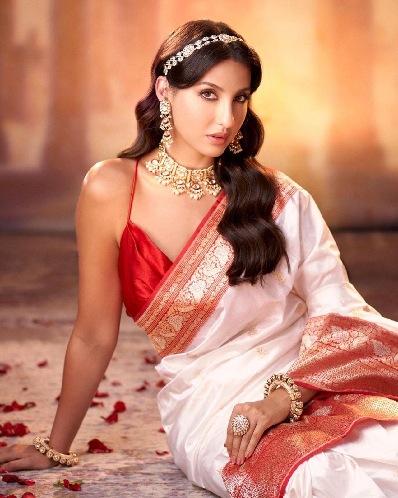 Nora Fatehi gives the Paro vibe in this white and red saree. She completed the look with traditional jewellery complete with a mang tikka, necklace and jhumkas