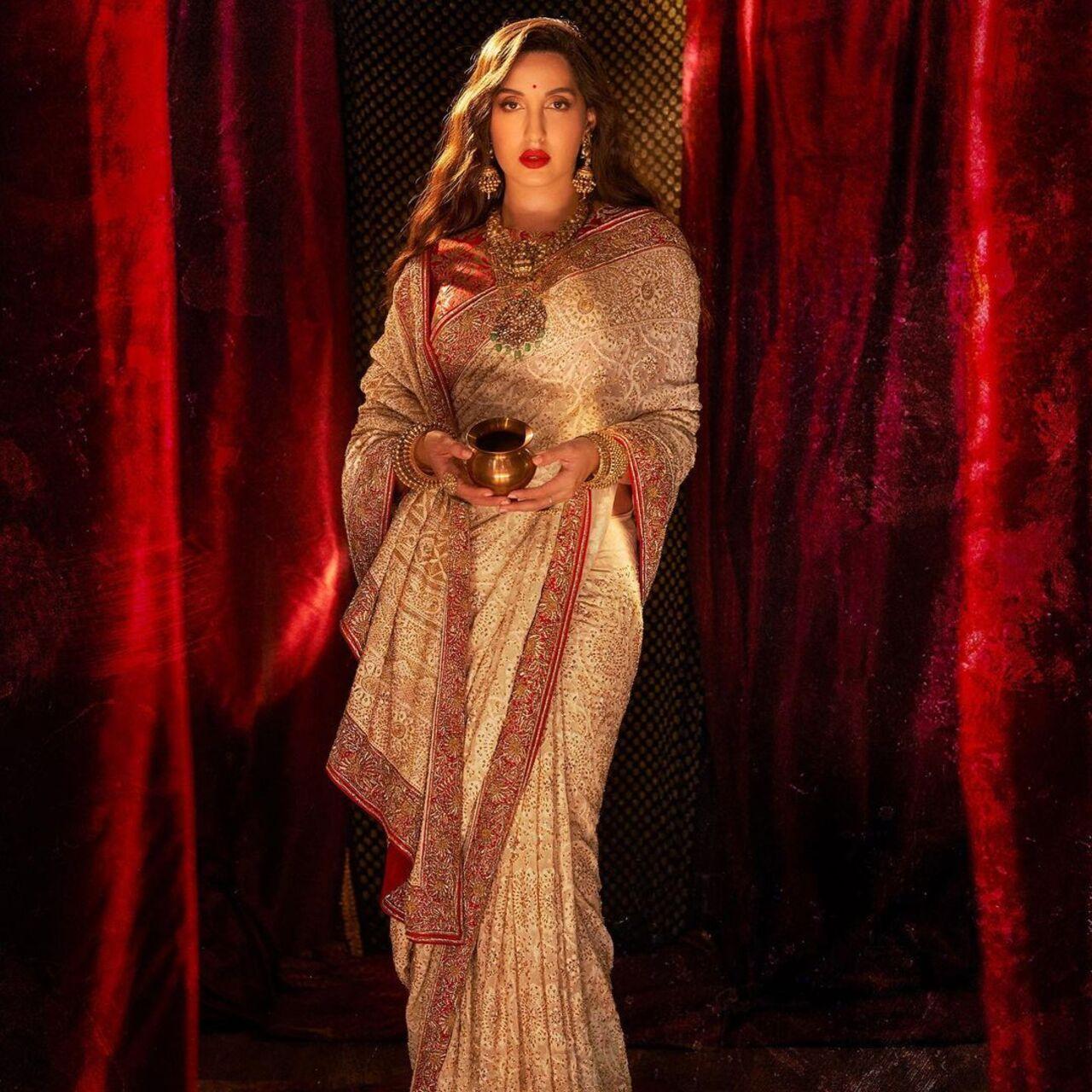 Nora looks like a Goddess in this off-white saree with intricate work. The red blouse, bold make-up and traditonal jewellery only enhance the overall look
