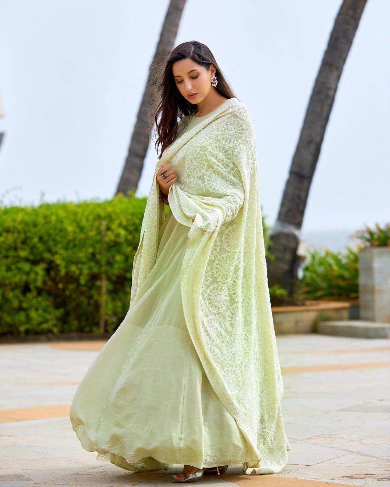 Nora Fatehi pulls off this simple anarkali suit that comes with a beautiful dupatta. She completed her look with shimmery jhumkas
