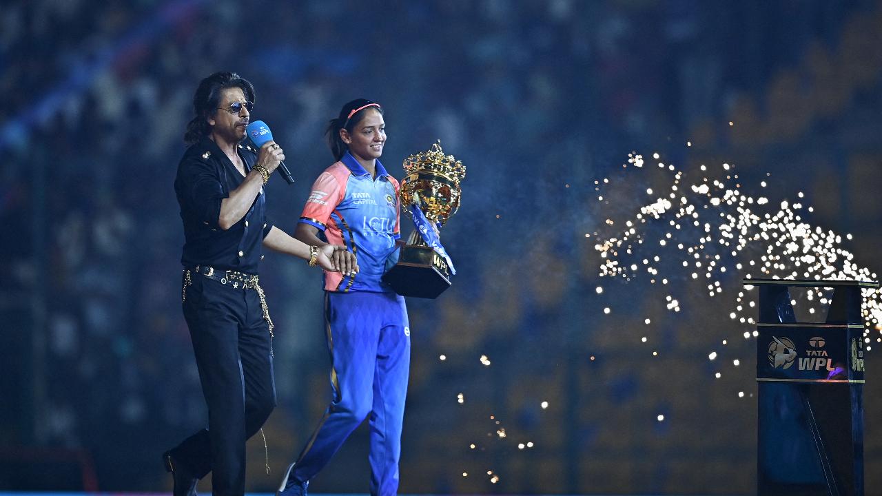 Mumbai Indians' captain Harmanpreet Kaur (R) carrying WPL trophy and Bollywood actor Shah Rukh Khan arrive during the opening ceremony of 2024 Women's Premier League (WPL)
