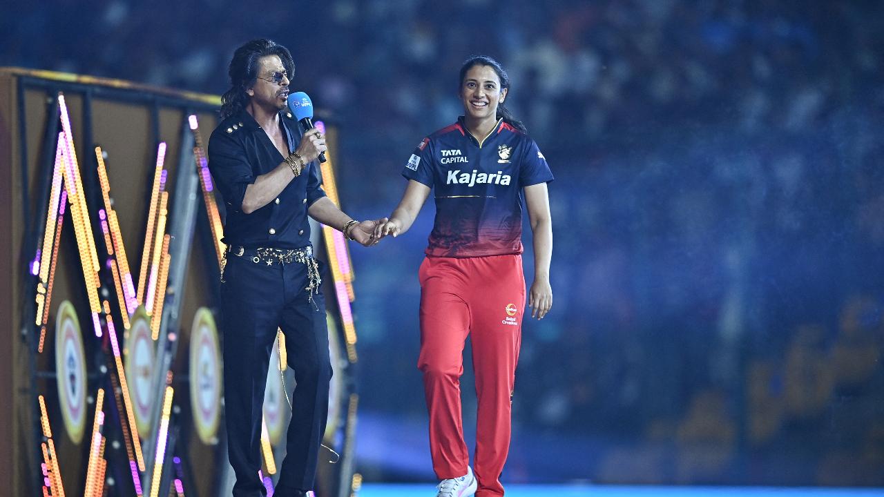 Royal Challengers Bangalore's captain Smriti Mandhana (R) and Bollywood actor Shah Rukh Khan gesture during the opening ceremony of 2024 Women's Premier League (WPL) before the start of first Twenty20 cricket match
