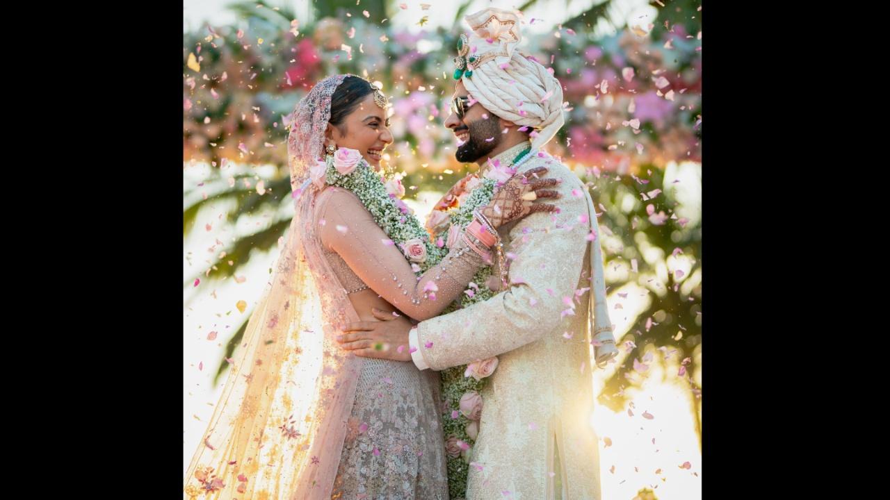 The lehenga was complemented by a blouse featuring sheer tulle sleeves adorned with graded pearls and crystal detailing. Adding layers of elegance to it was a structured tulle veil reminiscent of a floral cascade, adorned with whimsical stars and carefully scattered Swarovski crystals. The ensemble exuded enchanting sophistication, true to Rakul's spirited elegance