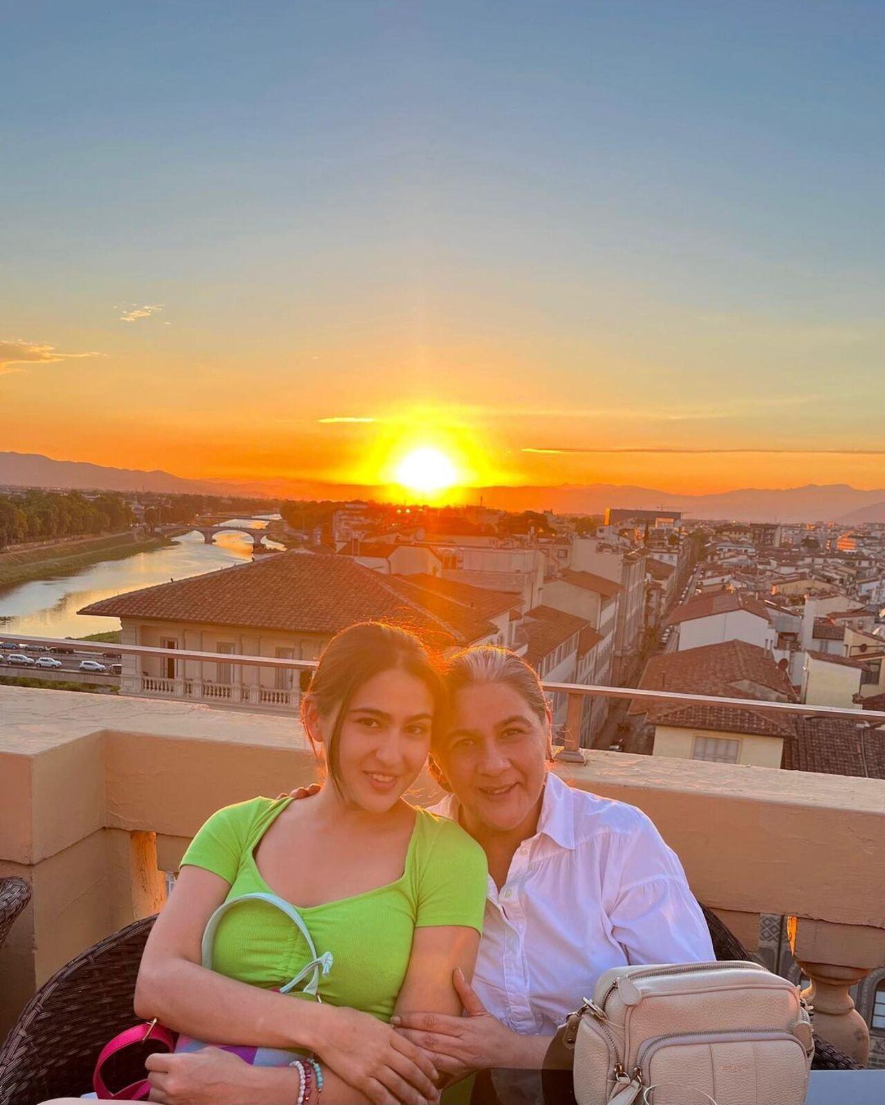 The mother-daughter duo pose in the foreground of a beautiful sunset in Florence
