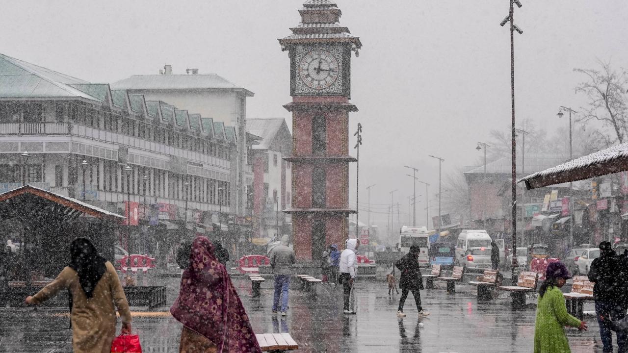 Commuters continue with their routines at Lal Chowk, Srinagar amid snowfall