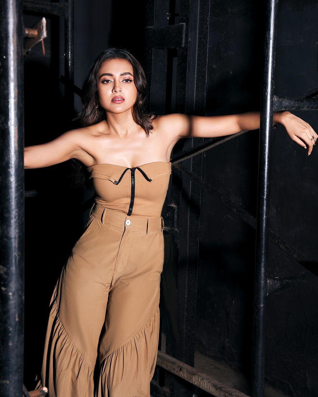 She opts for a beige strapless zipper top, gracefully accentuating her silhouette and embracing a departure from winter blues. Paired with stylish harem pants, the ensemble showcases Tejasswi's bold fashion choices