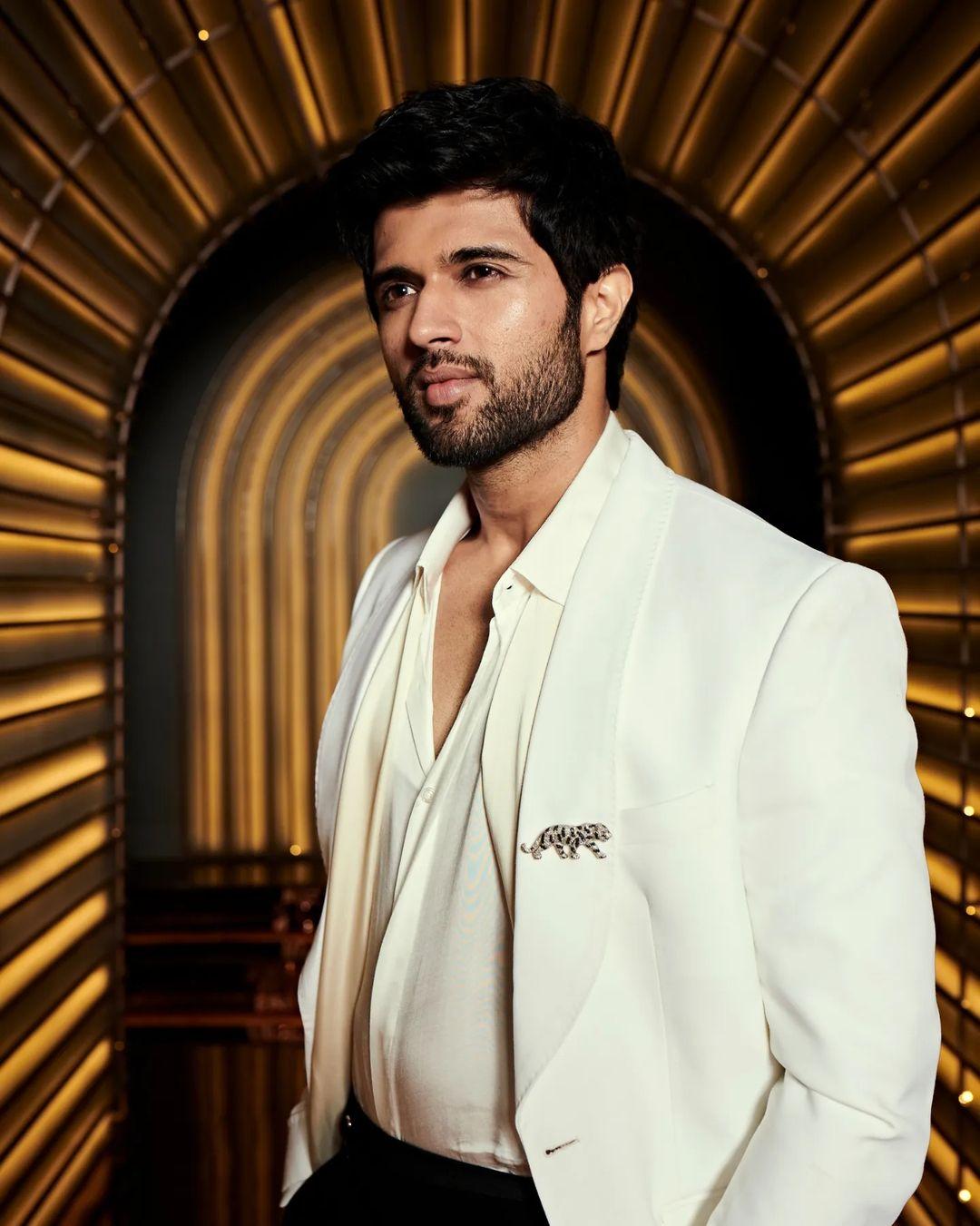 The  'Arjun Reddy' actor looked handsome in a classic white shirt, white blazer, and black pants. He elevated his outfit with a stylish pair of shiny slip-on oxfords