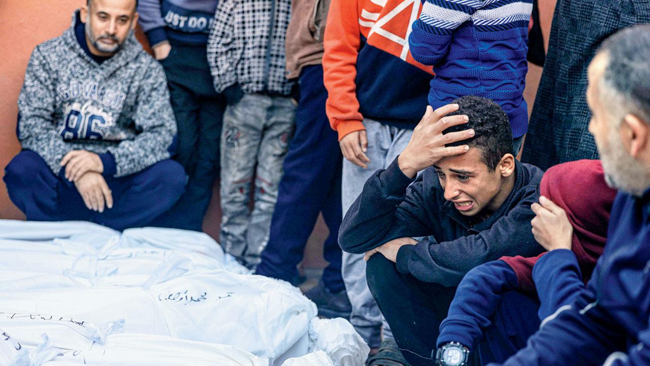 A young relative mourns over the bodies of the Salah and Abu Hatab families. Pics/AP