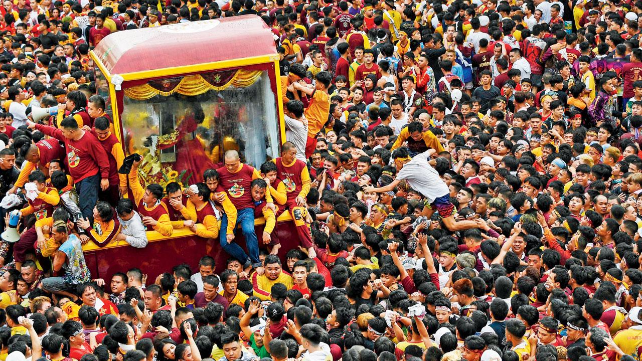 A man walks over devotees as he tries to reach the ‘Black Nazarene’