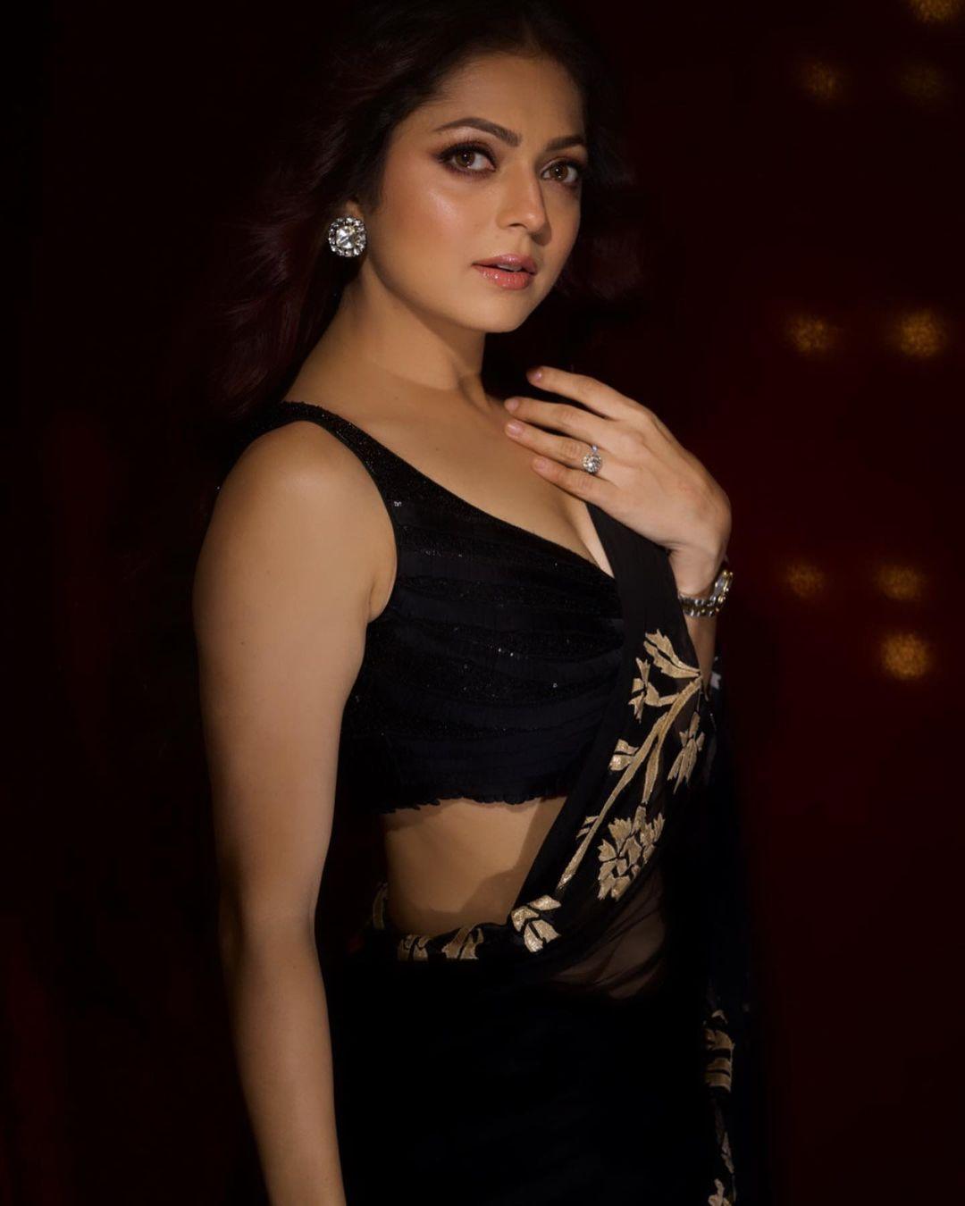 In this particular look, the actress adorned herself in a captivating see-through black saree adorned with red and white prints