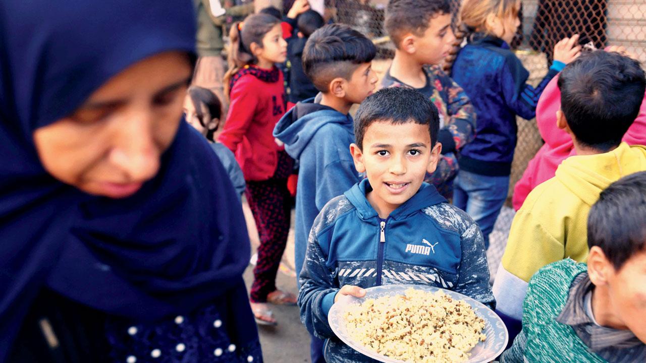 Displaced Palestinians who fled Khan Yunis line for food in Rafah. Pics/AP