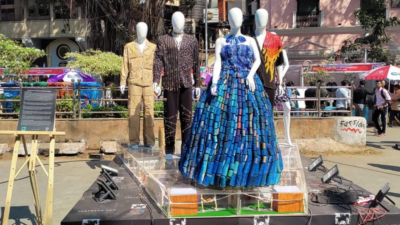 Created by Vastrado.com, this representation of a ramp with mannequins aims to showcase the creative fusion of fashion and elements of nature with the themes fire, water, space, label dress, and a co-ord set made of draft paper. While the fire is depicted with red, orange and yellow buttons arranged like a flickering flame, the one representing water is showcased through various shades of blue thread reels. Beyond these elements of nature, one mannequin depicts space is a jacket made from upcycled materials with zippers, eyelets and snap buttons, where the latter depicts distant stars. The label dress is made of of various tags and labels, which were left over from the factory, and are arranged in such a way to depict a 90s western dress. The last in this unique installation is the co-ord set that uses repurposed materials include pattern paper, pins, tape and measuring tape, depicting the process of making a dress. All of this highlights the need for eco-friendly fashion today.