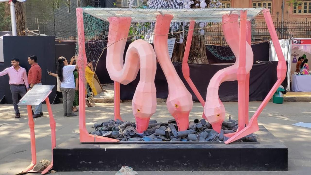 Artist Santanu Hazarika creates a bright pink installation of the Flamingos that catches the eye as you walk through the Kala Ghoda Arts Festival almost instantly. It is inspired by the famous flamingo migration that Mumbai experiences every winter, and depicts the co-existence of citizens and birds, and how they are exposed to plastic and waste. It is a reimagined version of Phoebe, the famous flamingo sculpture by Matthew Mazzotta.