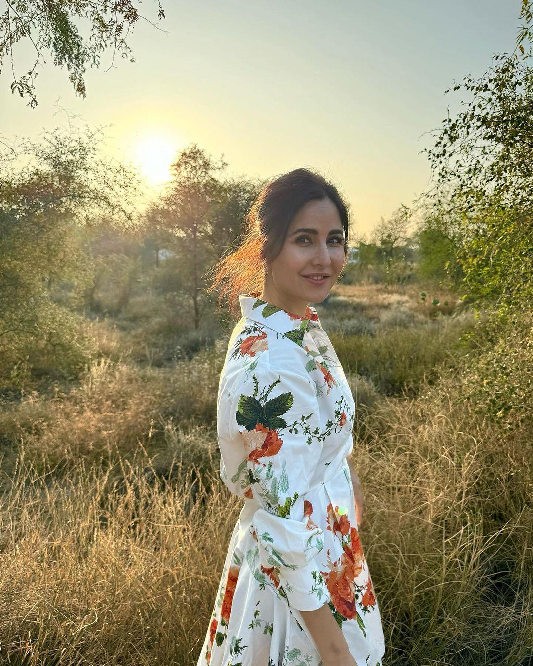 Katrina looks super cute with her hair tied in a messy bun as she poses in front of some bushes